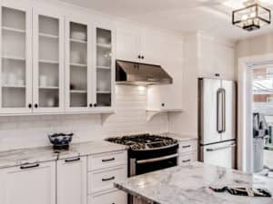 Cuisine rénovée, armoires shaker blanches et comptoir de marbre
