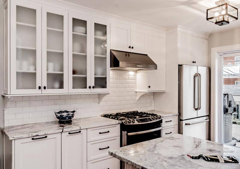 Cuisine rénovée, armoires shaker blanches et comptoir de marbre