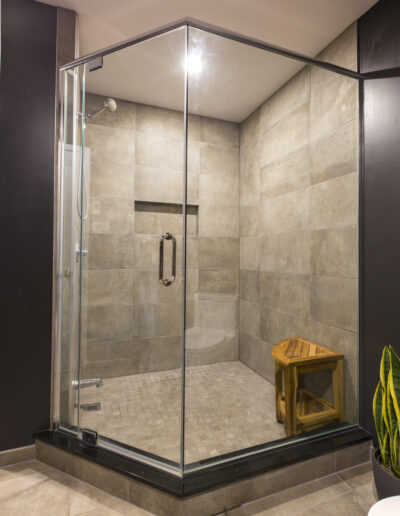 Nouvelle salle de bain, grande douche en verre avec petit banc en bois rustique reprenant le style scandinave de la salle de bain